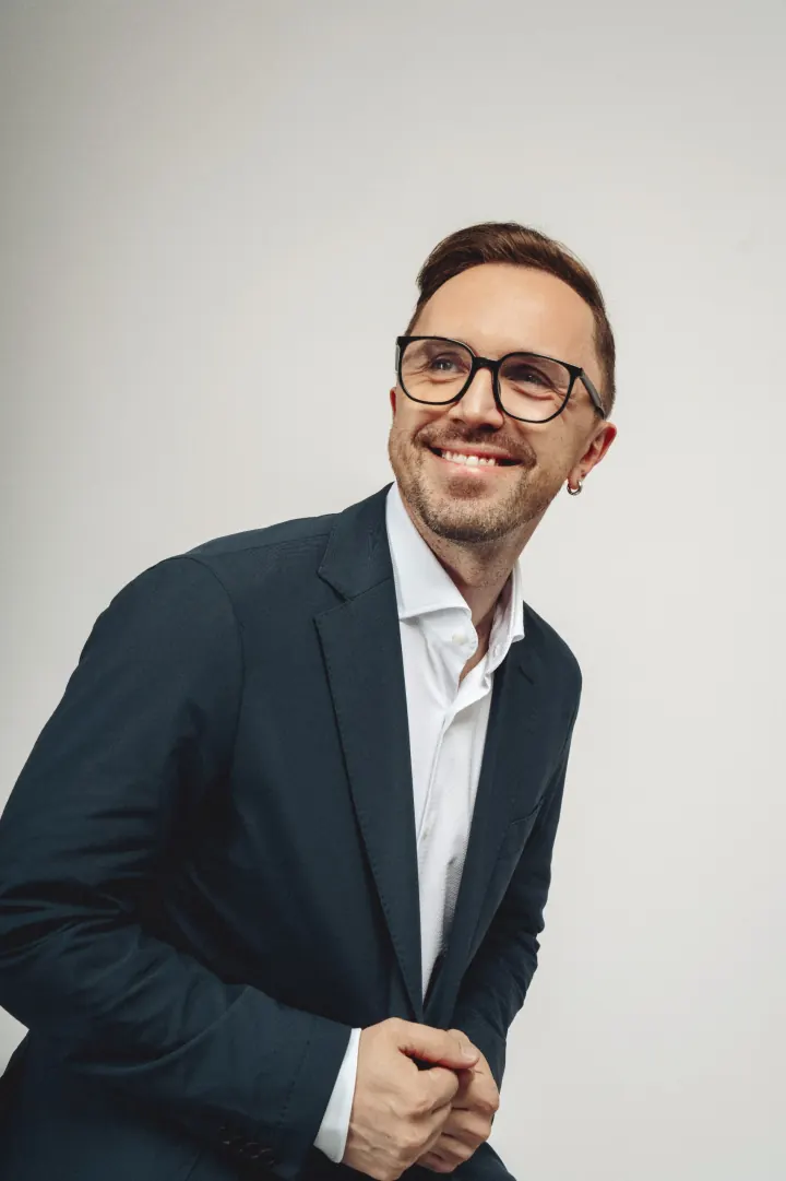 Portrait of Stanislav Kukharkov, host and format author of Playing Talking, mid-performance under stage lighting